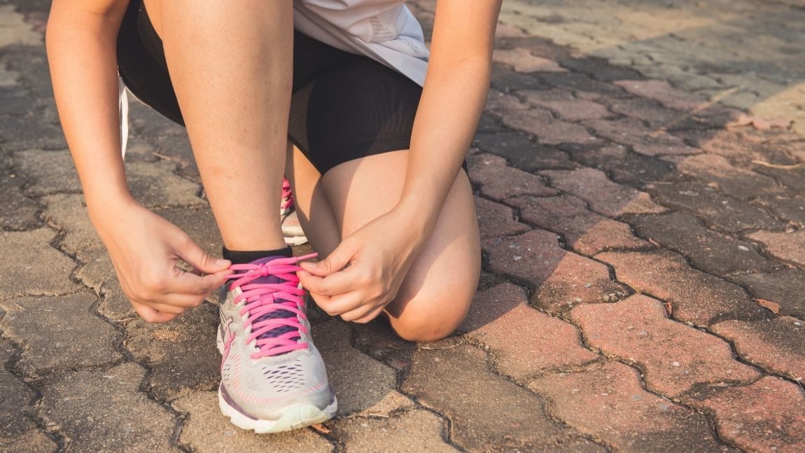 Pregnant woman tying shoelace